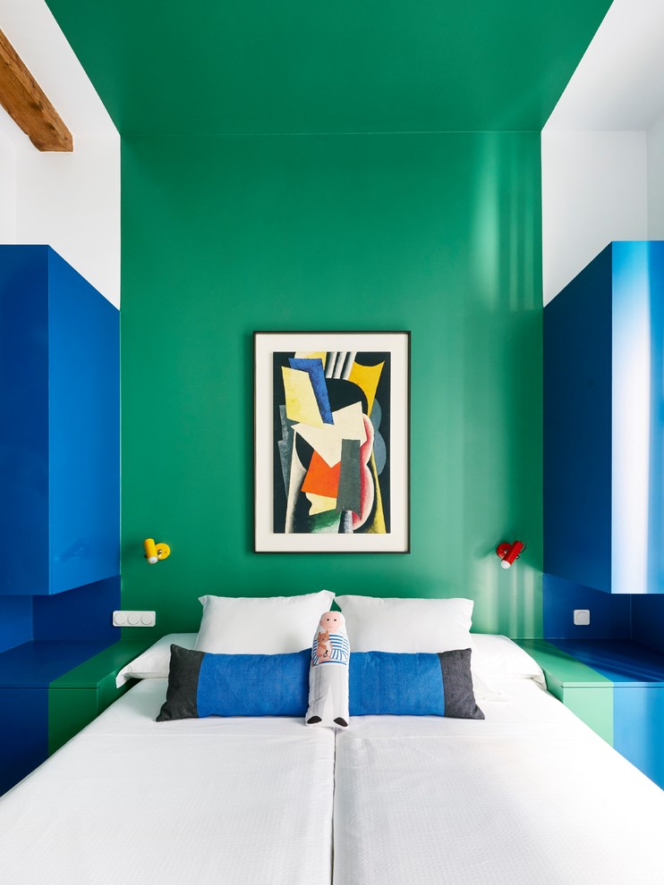 Foto på ett eklektiskt sovrum, med gröna väggar och mellanmörkt trägolv
