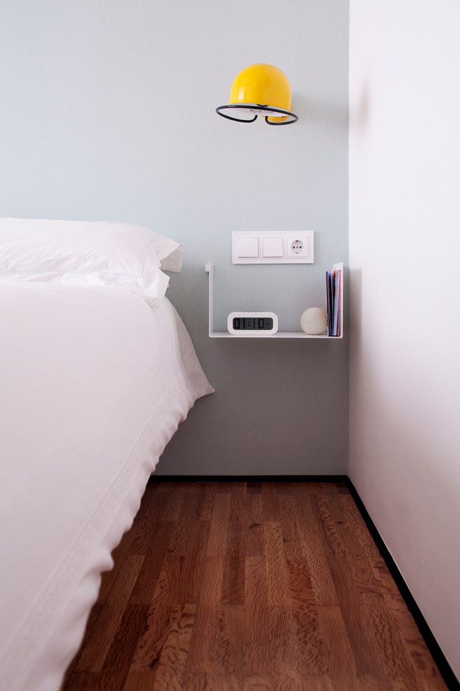 На фото: хозяйская спальня среднего размера в скандинавском стиле с разноцветными стенами и темным паркетным полом без камина с