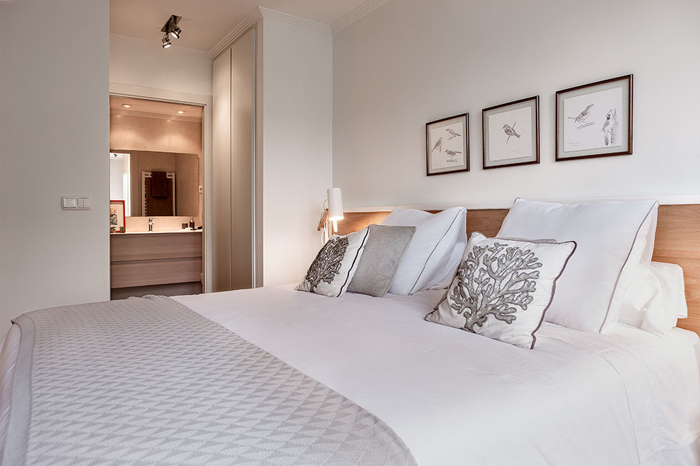 Foto de dormitorio principal minimalista pequeño con paredes blancas y suelo de madera clara