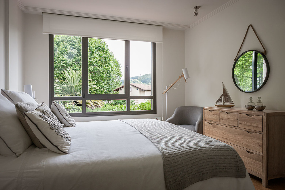 Diseño de dormitorio principal minimalista pequeño con paredes blancas y suelo de madera clara