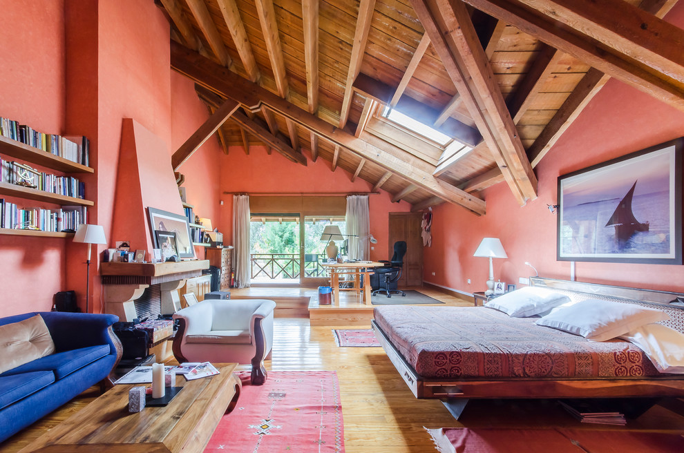 На фото: большая хозяйская спальня в стиле рустика с красными стенами, паркетным полом среднего тона, стандартным камином и фасадом камина из камня с