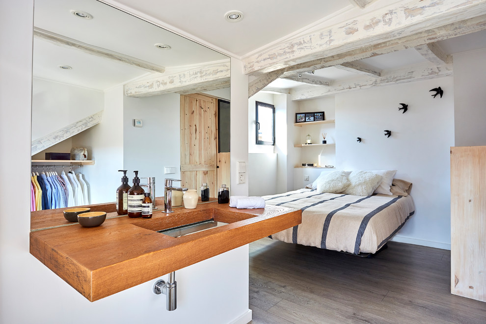 Imagen de dormitorio principal mediterráneo de tamaño medio con paredes blancas, suelo de madera oscura y suelo gris
