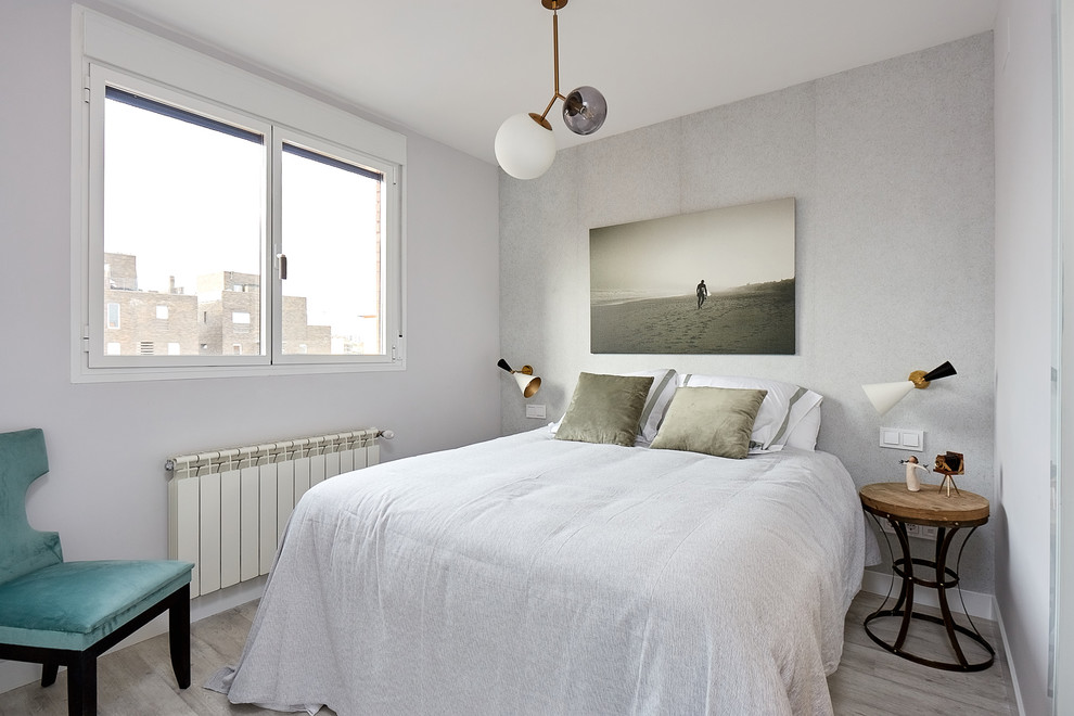 Ejemplo de habitación de invitados actual con paredes grises, suelo de madera clara y suelo gris