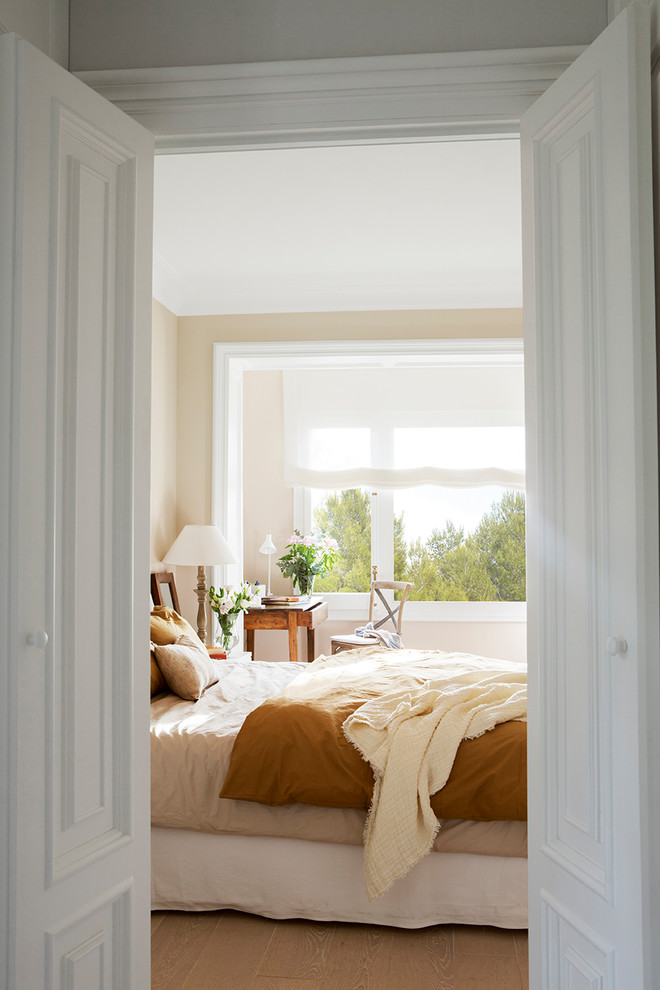 Exemple d'une grande chambre parentale chic avec un mur beige, parquet clair et un sol beige.