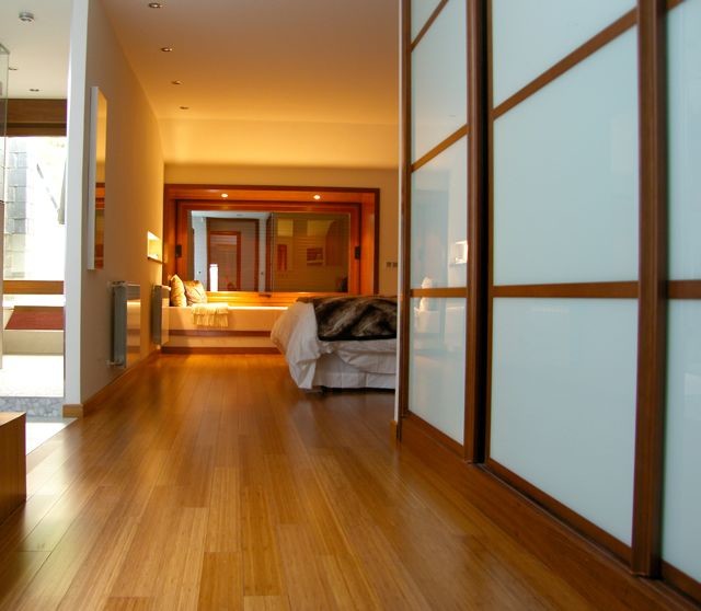 На фото: большая хозяйская спальня в современном стиле с коричневыми стенами, паркетным полом среднего тона и коричневым полом без камина