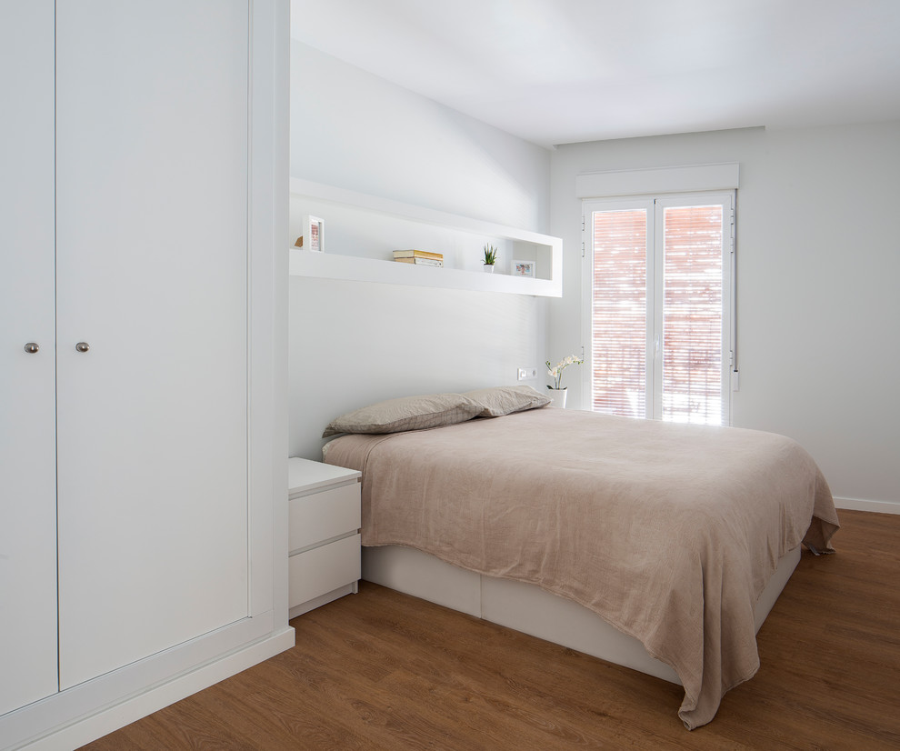 Ejemplo de dormitorio contemporáneo con paredes blancas, suelo de madera en tonos medios y suelo marrón