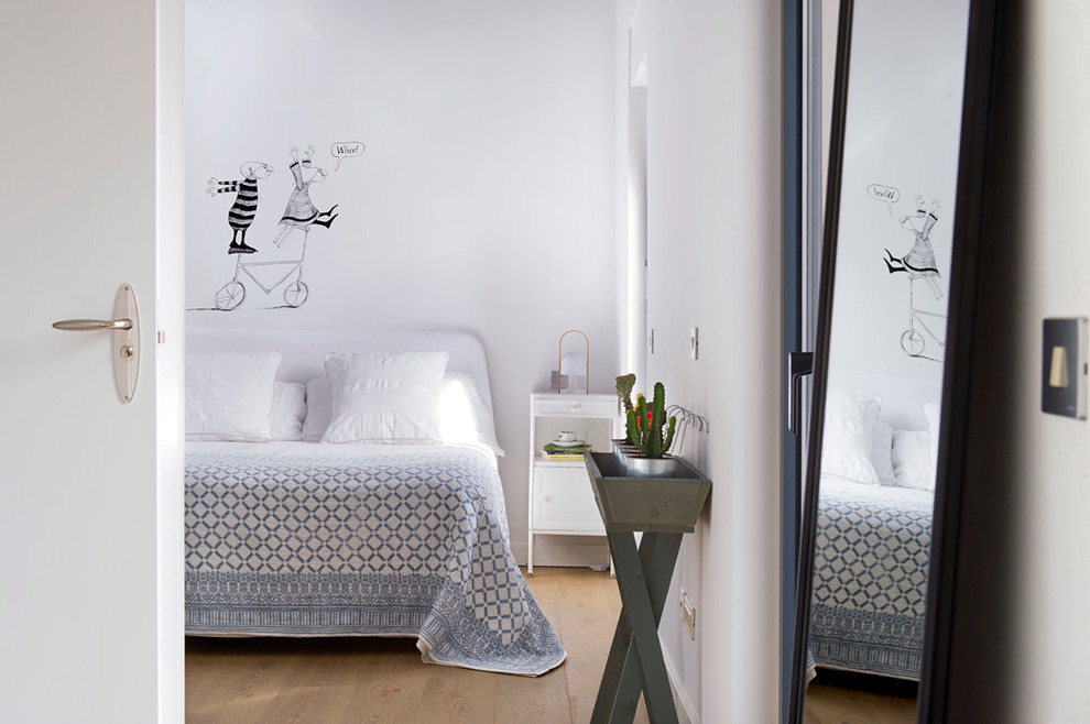 Diseño de dormitorio principal actual de tamaño medio sin chimenea con paredes blancas y suelo de madera clara