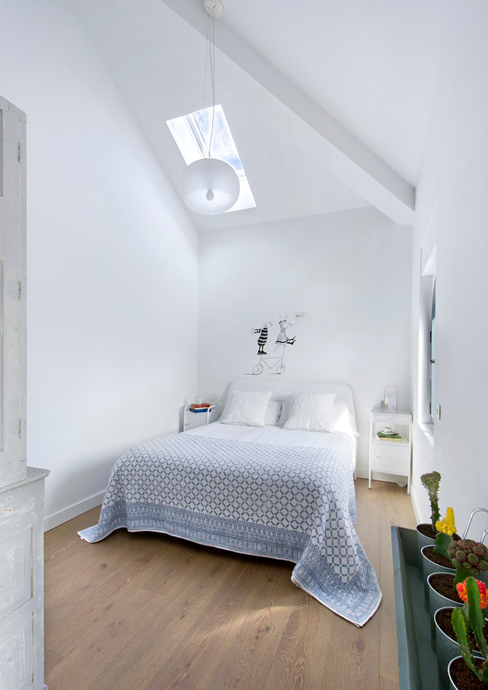 Immagine di una camera degli ospiti moderna di medie dimensioni con pareti bianche, pavimento in legno massello medio e nessun camino