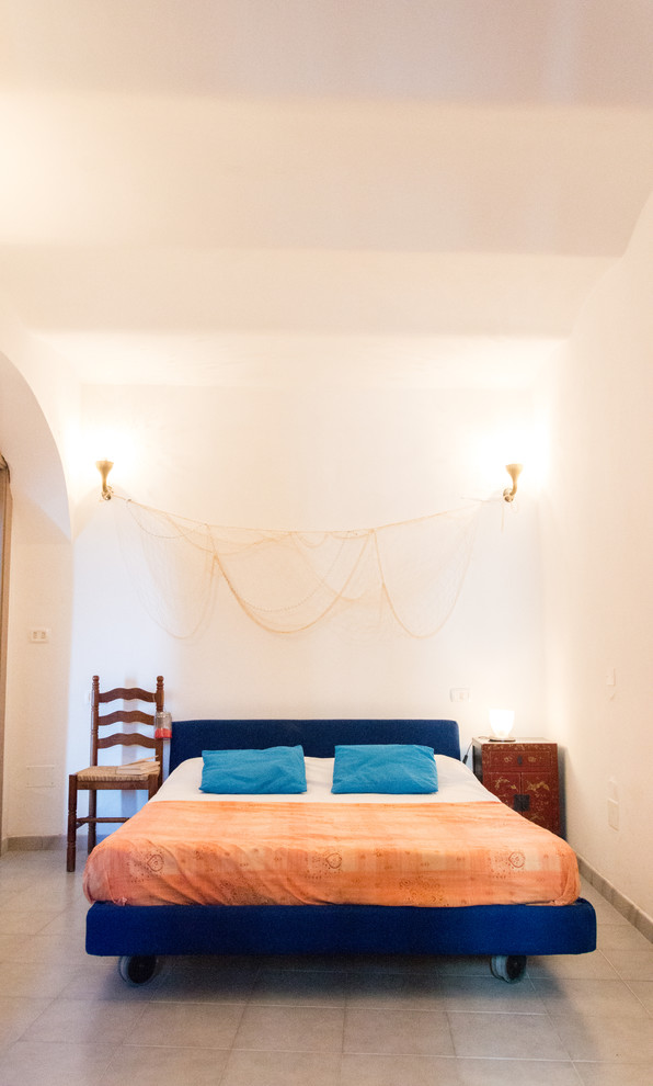 Modelo de dormitorio principal mediterráneo de tamaño medio con paredes blancas