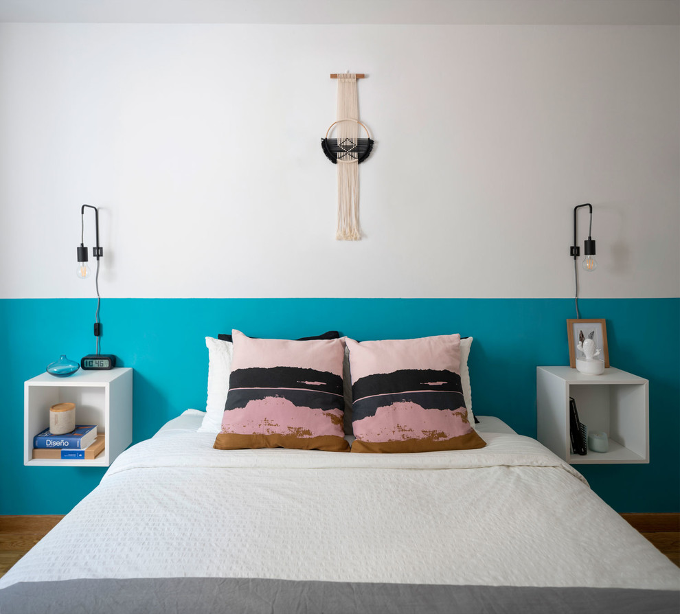 Modelo de dormitorio principal escandinavo de tamaño medio con suelo de madera en tonos medios, suelo marrón y paredes blancas