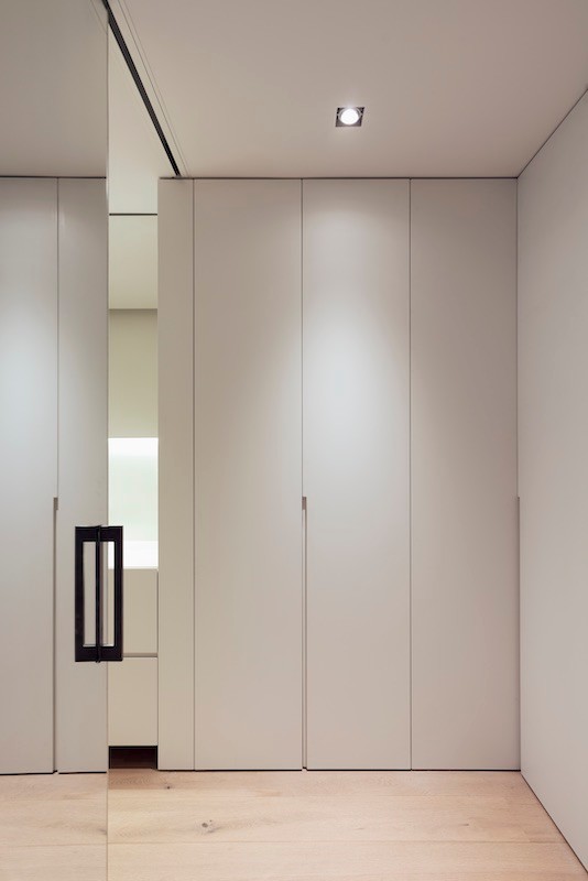 Diseño de dormitorio principal minimalista de tamaño medio con paredes blancas y suelo de madera clara