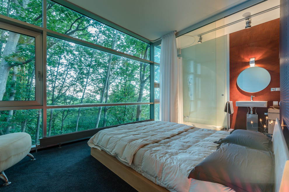 Ejemplo de dormitorio principal industrial de tamaño medio sin chimenea con paredes multicolor y moqueta
