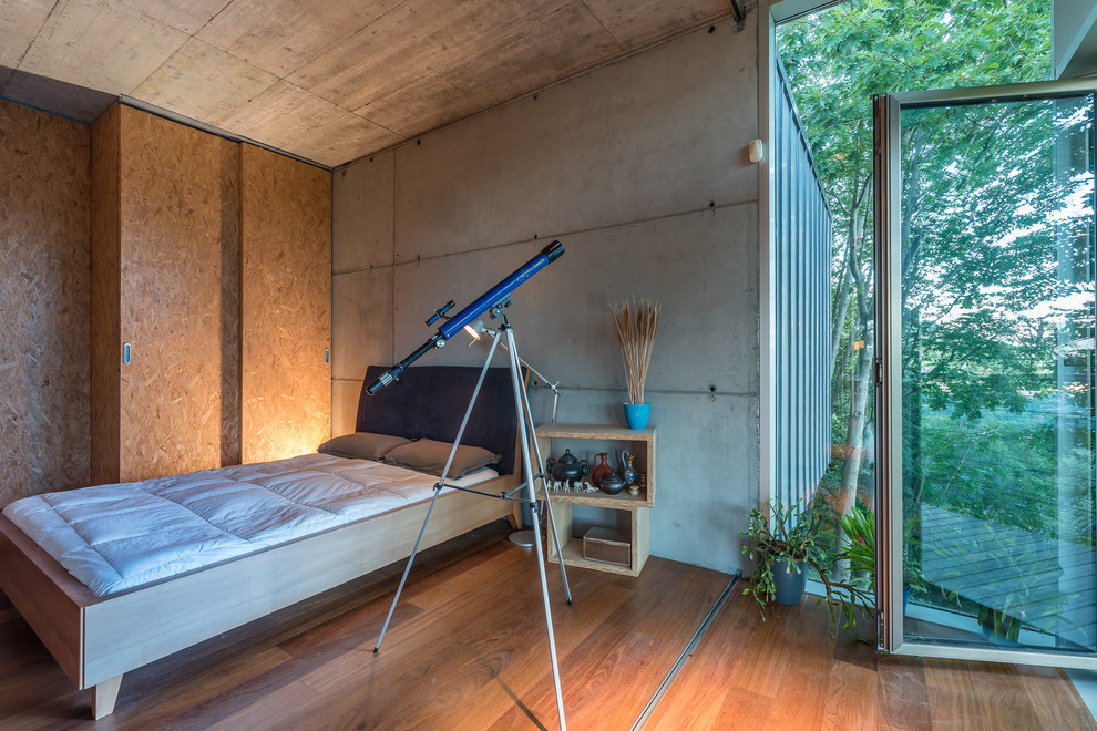 Ejemplo de dormitorio principal industrial de tamaño medio sin chimenea con paredes multicolor y suelo de madera en tonos medios