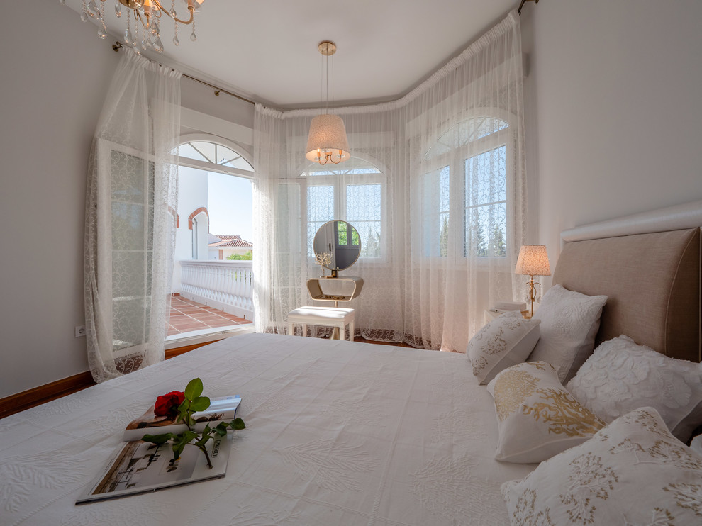 Mittelgroßes Shabby-Style Hauptschlafzimmer mit weißer Wandfarbe und braunem Holzboden in Malaga