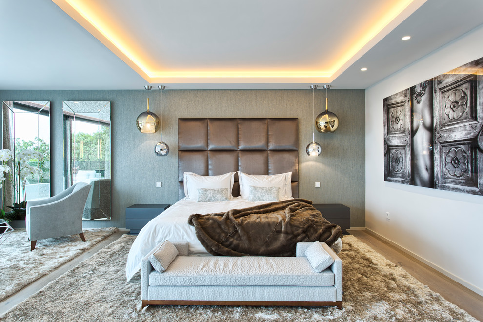 Esempio di una camera matrimoniale design con pareti bianche, pavimento in legno massello medio e pavimento beige