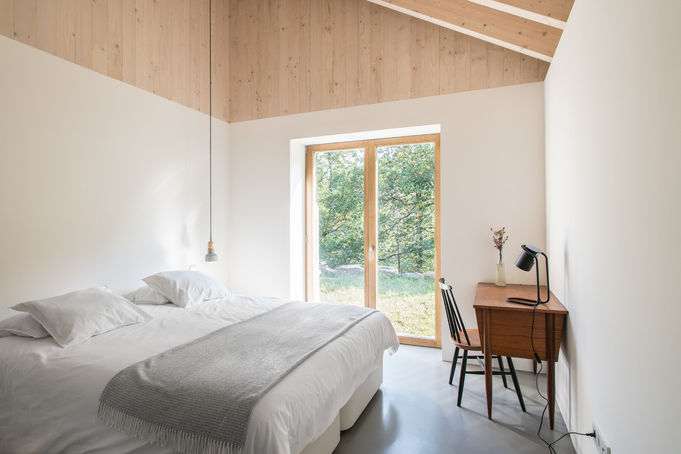 Стильный дизайн: хозяйская спальня среднего размера в скандинавском стиле с белыми стенами, бетонным полом и серым полом без камина - последний тренд