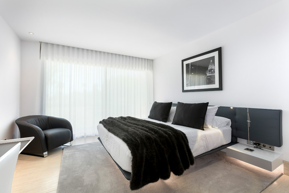 Foto de dormitorio contemporáneo con paredes blancas y suelo beige