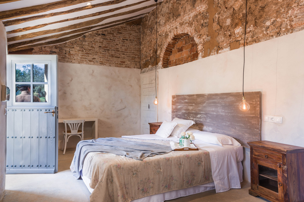 Mediterranes Schlafzimmer mit beiger Wandfarbe, Betonboden und grauem Boden in Sonstige