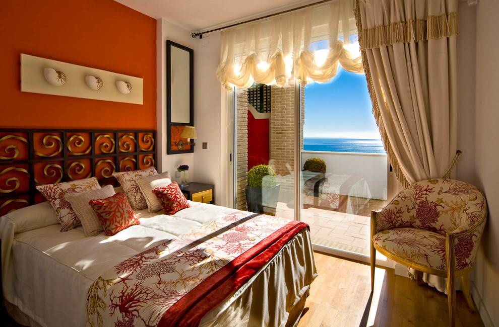 マドリードにある中くらいな地中海スタイルのおしゃれな主寝室 (オレンジの壁、無垢フローリング、暖炉なし) のインテリア