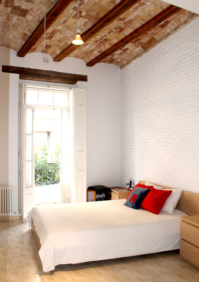 Imagen de dormitorio principal urbano de tamaño medio sin chimenea con paredes blancas y suelo de madera en tonos medios