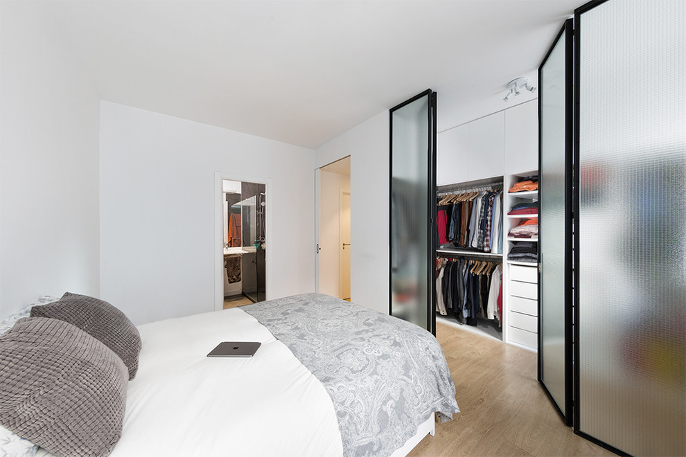 Modelo de dormitorio principal clásico renovado de tamaño medio sin chimenea con paredes blancas y suelo de madera en tonos medios
