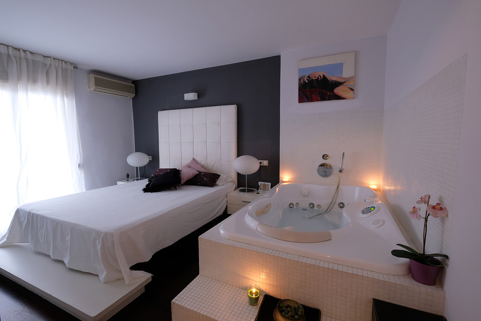 バレンシアにある広いモダンスタイルのおしゃれな主寝室 (白い壁、濃色無垢フローリング、茶色い床)
