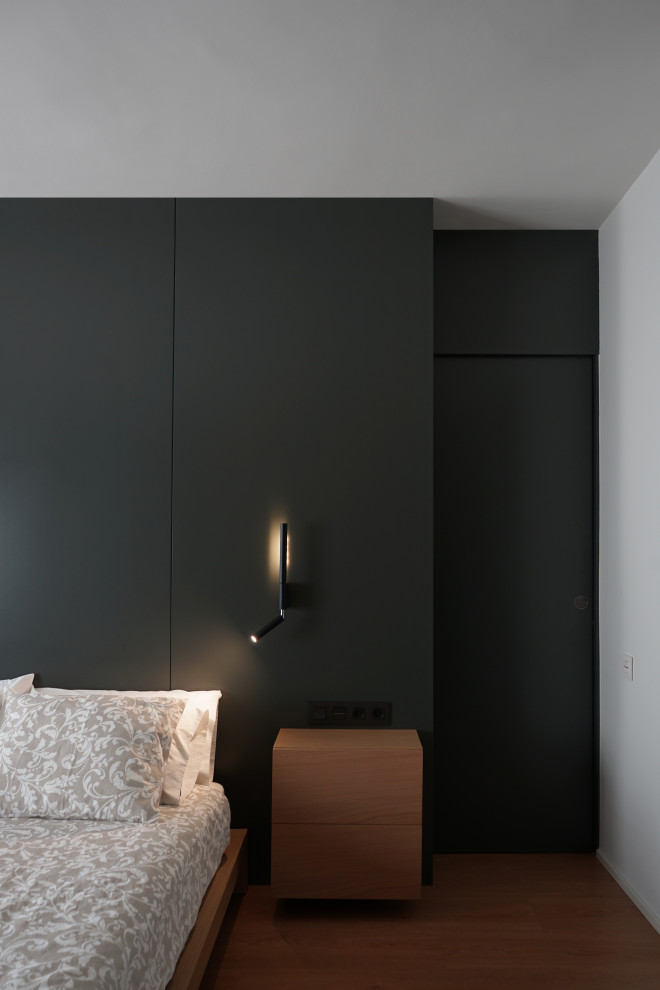Diseño de dormitorio principal actual con paredes verdes y suelo de madera en tonos medios