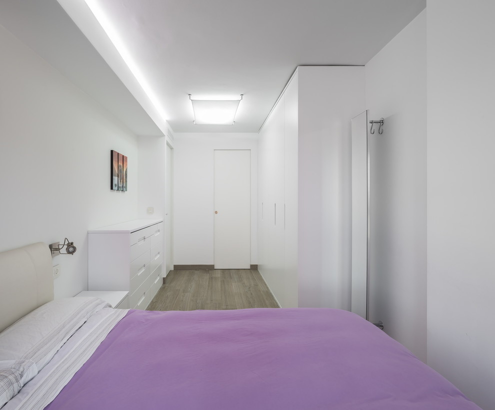 Foto de dormitorio principal contemporáneo de tamaño medio sin chimenea con paredes blancas y suelo de madera en tonos medios