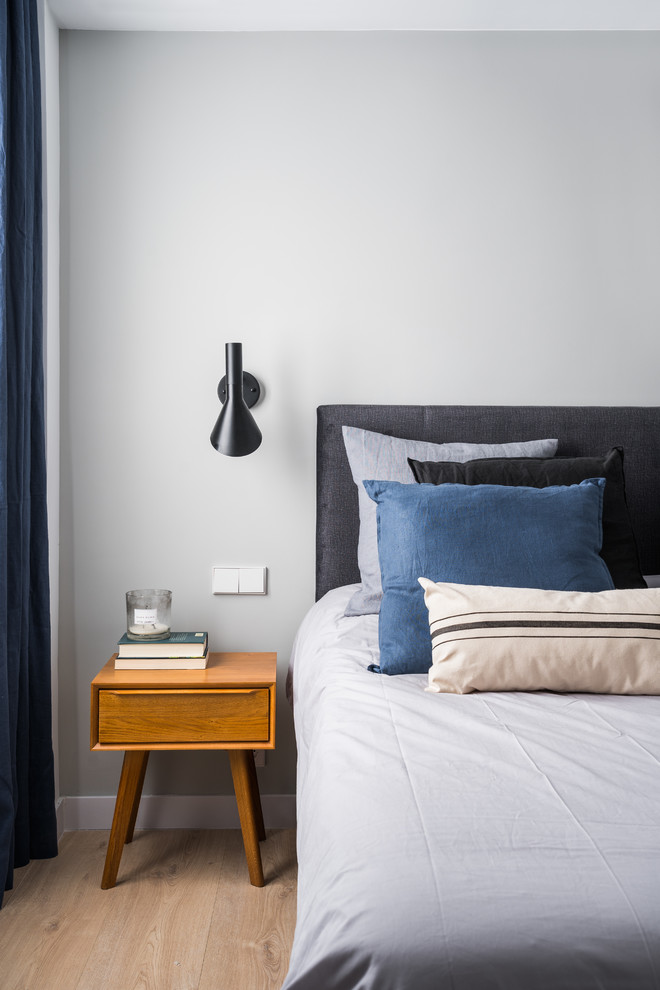 Imagen de dormitorio actual con paredes grises, suelo de madera clara y suelo beige