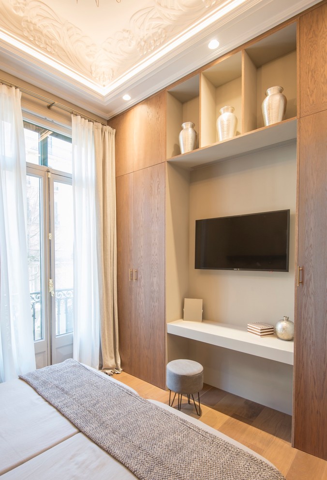 Modelo de dormitorio principal actual de tamaño medio con paredes grises, suelo de madera en tonos medios y suelo beige
