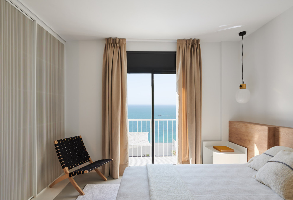 Mittelgroßes Modernes Schlafzimmer im Loft-Style mit weißer Wandfarbe, Betonboden und grauem Boden in Barcelona