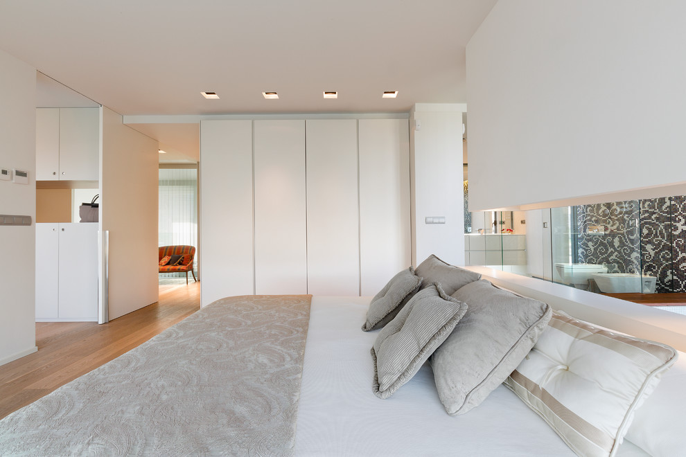 他の地域にある広いコンテンポラリースタイルのおしゃれなロフト寝室 (白い壁、無垢フローリング、暖炉なし)
