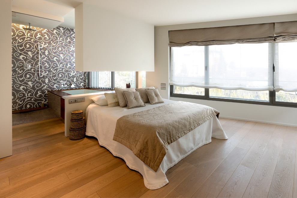 Großes Modernes Schlafzimmer ohne Kamin, im Loft-Style mit weißer Wandfarbe und braunem Holzboden in Sonstige