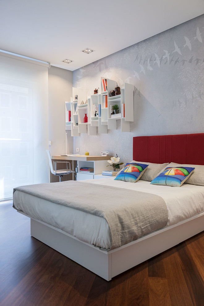 На фото: хозяйская спальня среднего размера в современном стиле с темным паркетным полом, серыми стенами и рабочим местом без камина