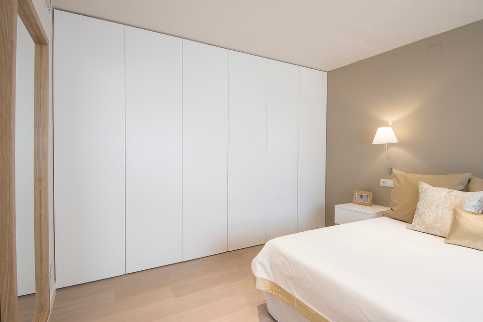 На фото: хозяйская спальня среднего размера в современном стиле с бежевыми стенами и светлым паркетным полом без камина