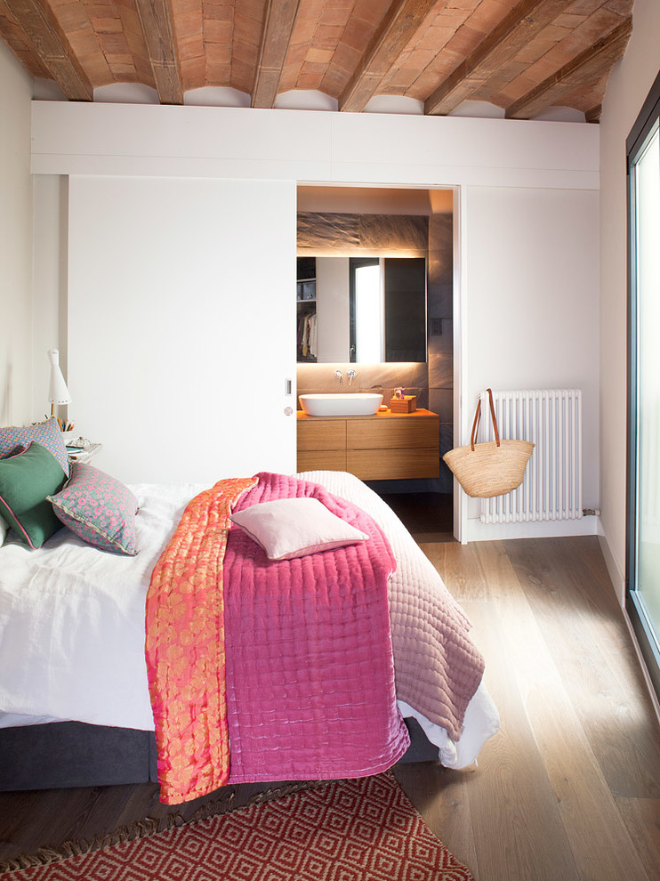 Modelo de dormitorio principal nórdico de tamaño medio sin chimenea con paredes blancas y suelo de madera en tonos medios