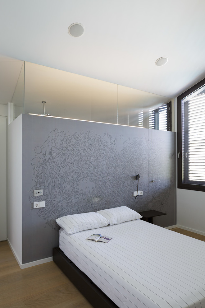 Exemple d'une chambre d'amis tendance avec un mur blanc, un sol en bois brun et un sol marron.