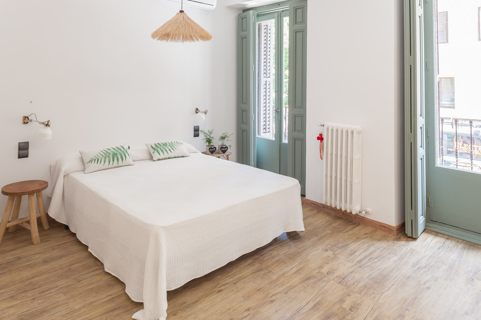 Imagen de dormitorio principal tropical sin chimenea con paredes blancas y suelo beige