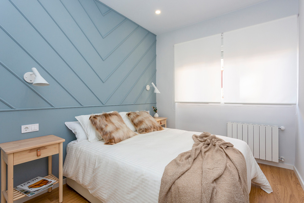 Esempio di una camera matrimoniale contemporanea con pareti blu e pavimento in legno massello medio