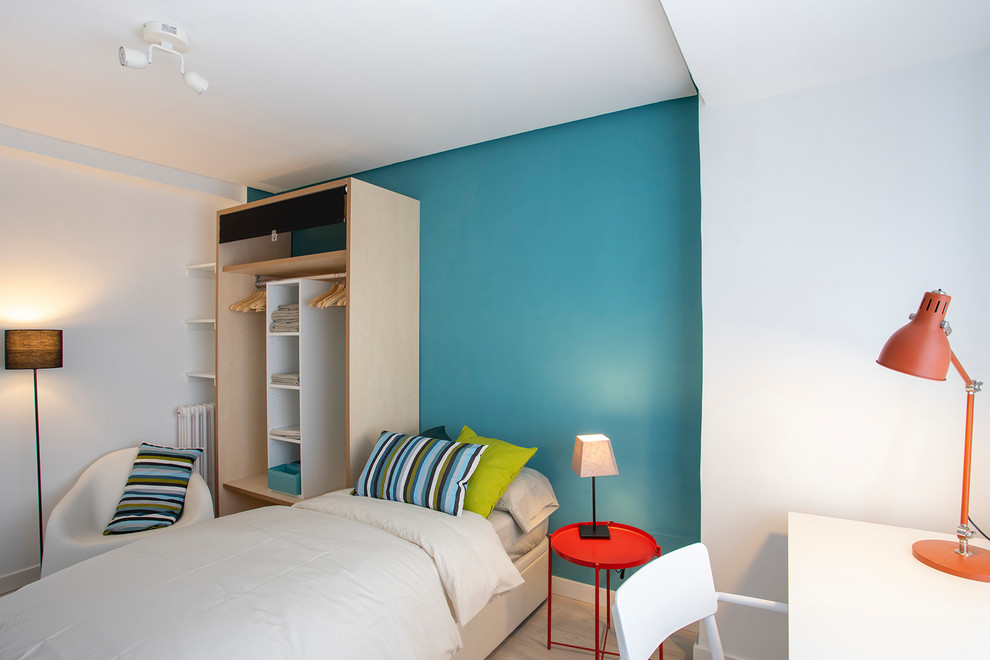Idéer för ett litet modernt sovrum, med blå väggar och laminatgolv