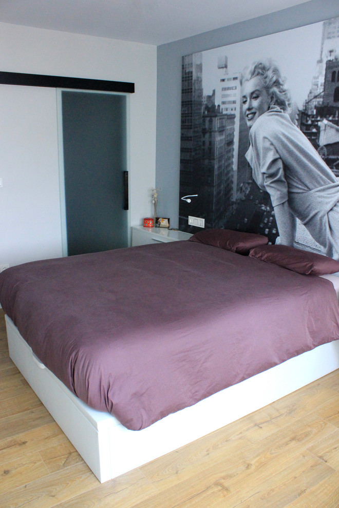 Ejemplo de dormitorio principal contemporáneo de tamaño medio sin chimenea con paredes multicolor y suelo de madera en tonos medios