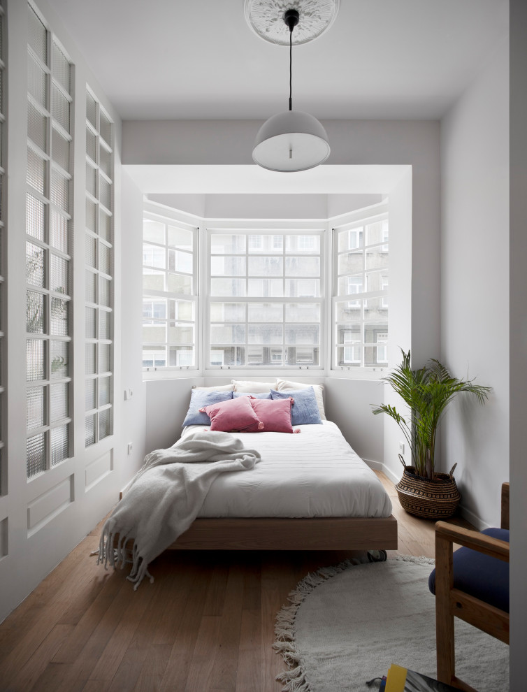 Idee per una camera da letto scandinava con pareti bianche, pavimento in legno massello medio e pavimento marrone