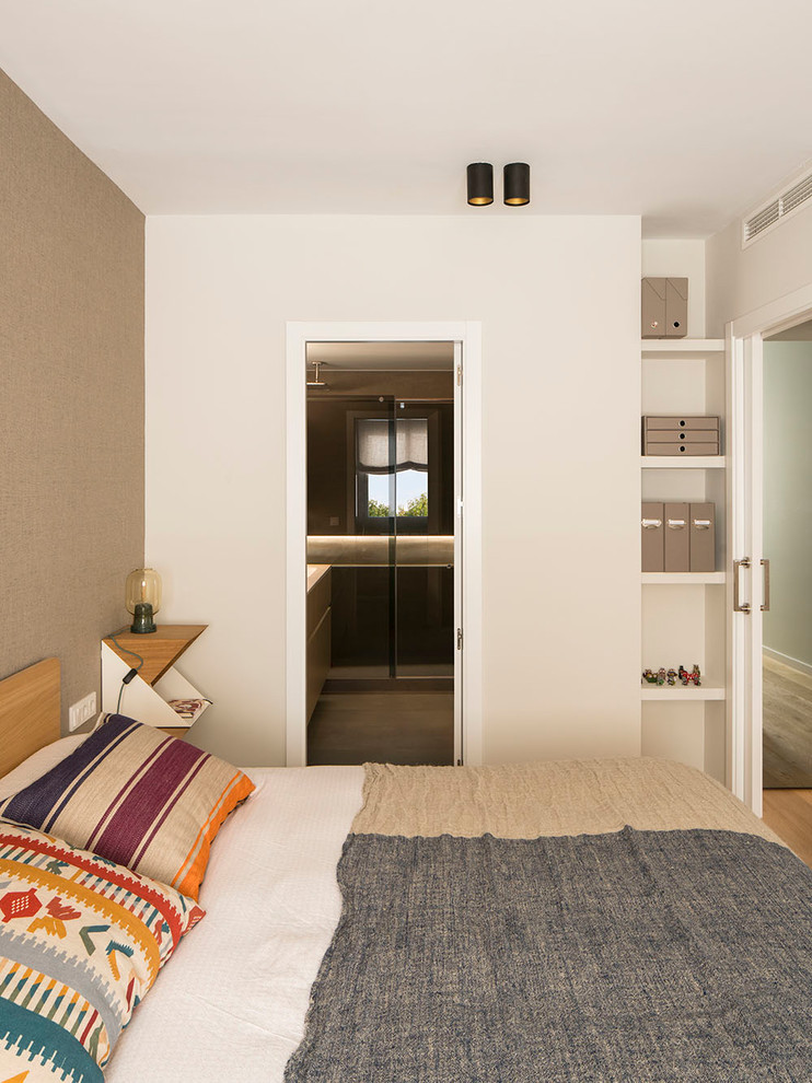 Foto de dormitorio principal actual grande sin chimenea con paredes beige, suelo de madera en tonos medios y suelo marrón