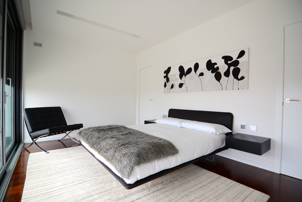 Foto de dormitorio principal contemporáneo de tamaño medio sin chimenea con paredes blancas y suelo de madera oscura