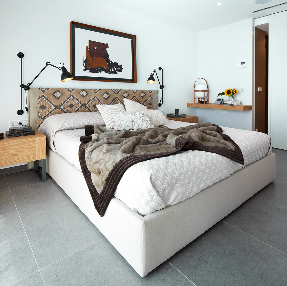 This is an example of a medium sized contemporary master bedroom in Barcelona with white walls, ceramic flooring and no fireplace.