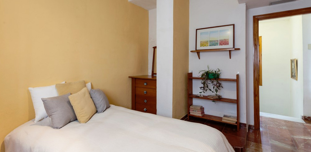 他の地域にある中くらいなラスティックスタイルのおしゃれな客用寝室 (ベージュの壁、茶色い床、大理石の床)