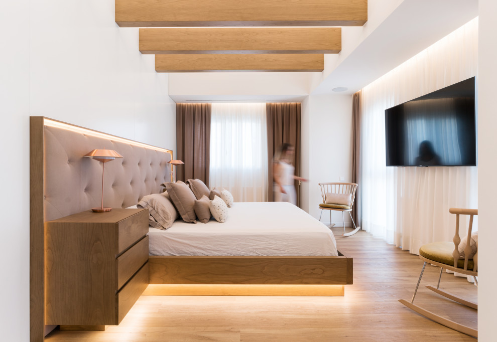 Ejemplo de dormitorio principal contemporáneo grande con paredes blancas, suelo de madera en tonos medios y suelo beige