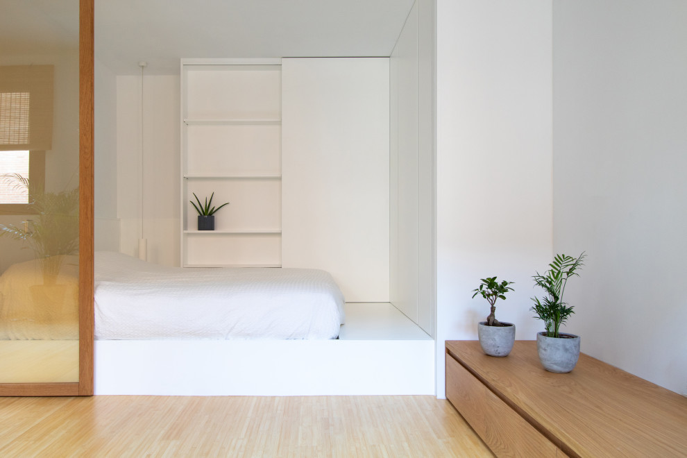 Foto de dormitorio tipo loft nórdico pequeño con paredes blancas y suelo de bambú