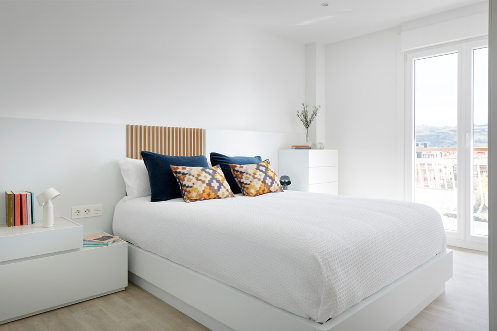На фото: хозяйская спальня среднего размера в скандинавском стиле с белыми стенами, светлым паркетным полом и бежевым полом без камина