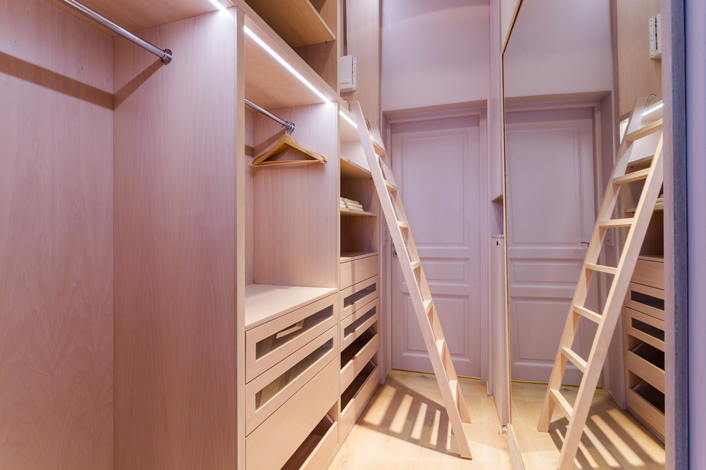 Kleines Modernes Ankleidezimmer mit Ankleidebereich, offenen Schränken, hellen Holzschränken, hellem Holzboden und braunem Boden in Paris